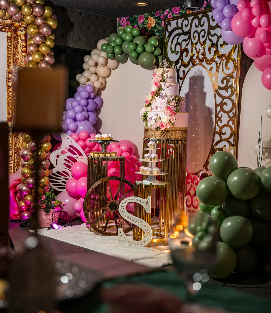 A festive party setup with balloons, cake, and decorations